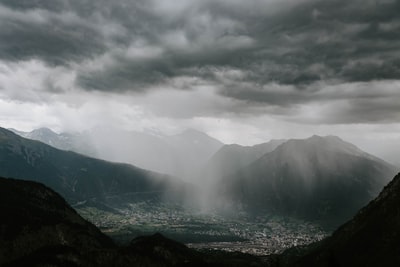 灰色云层中群山环抱城市的航空摄影